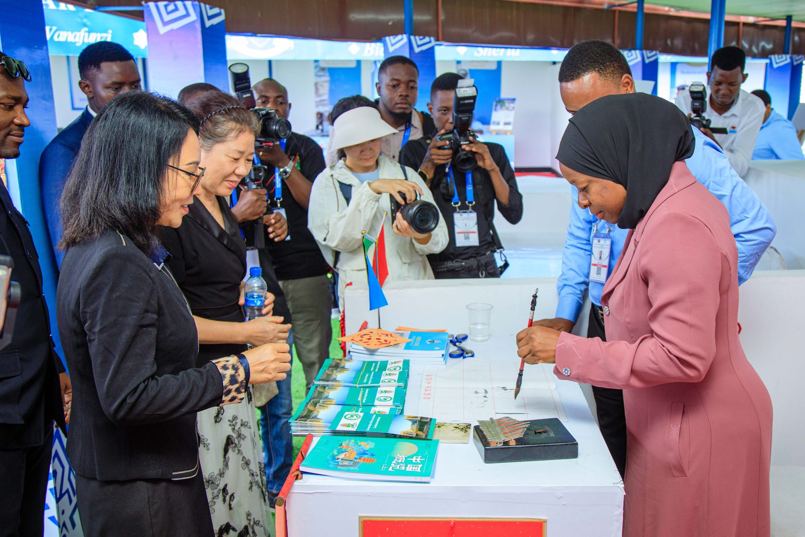 Trying Chinese calligraphy at the CI exhibition stand